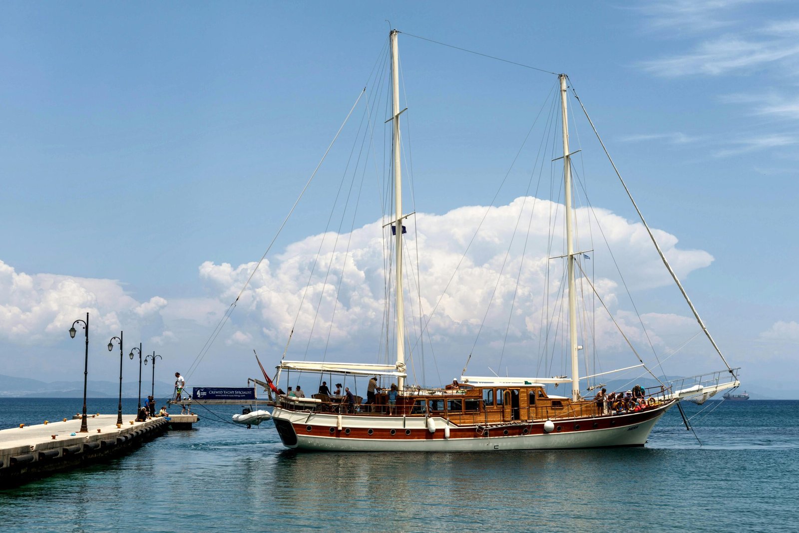 Barco de vela profesional atracado en puerto con pasajeros a bordo durante una experiencia náutica de éxito
